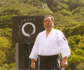Fumio Toyoda Shihan standing before an enso calligraphy at Chozen-ji temple, Hawaii